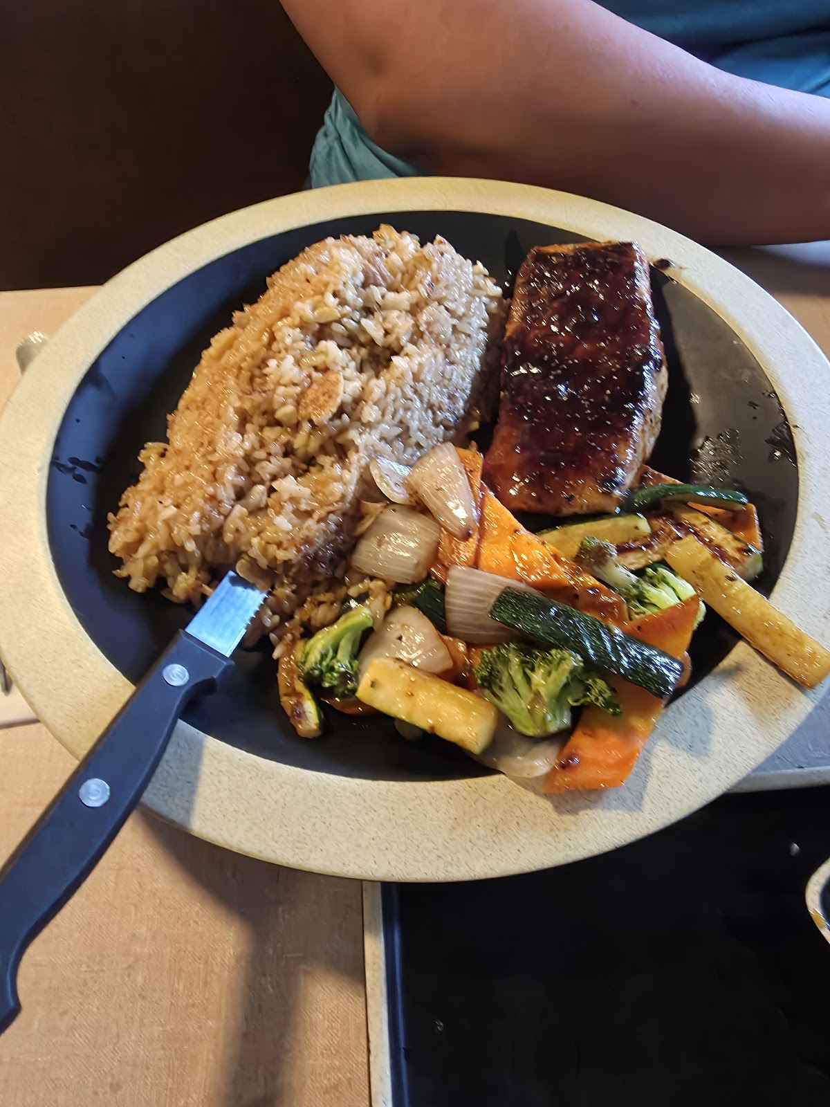 Salmon teppanyaki with rice and grilled vegetables on a hibachi plate